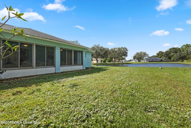 view of yard with a water view and a sunroom