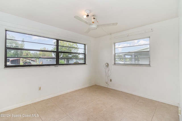 tiled spare room featuring ceiling fan