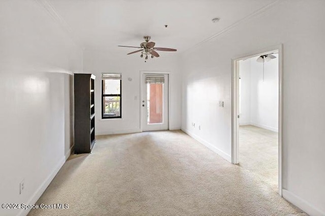 carpeted empty room featuring ceiling fan and ornamental molding