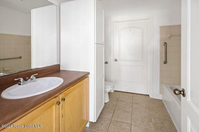 bathroom with toilet, vanity, and tile patterned floors