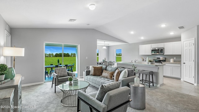 living room with lofted ceiling, a healthy amount of sunlight, and light colored carpet