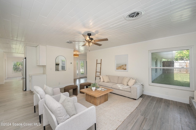 living room featuring ceiling fan, light hardwood / wood-style flooring, and a healthy amount of sunlight