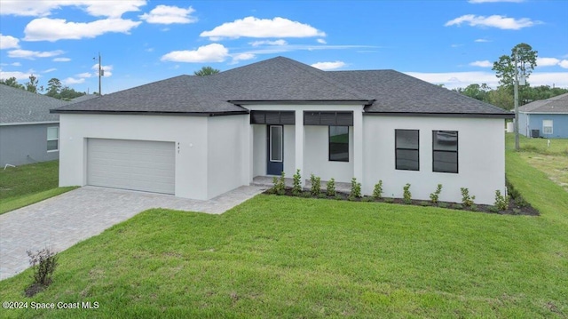 view of front facade featuring roof with shingles, an attached garage, and stucco siding