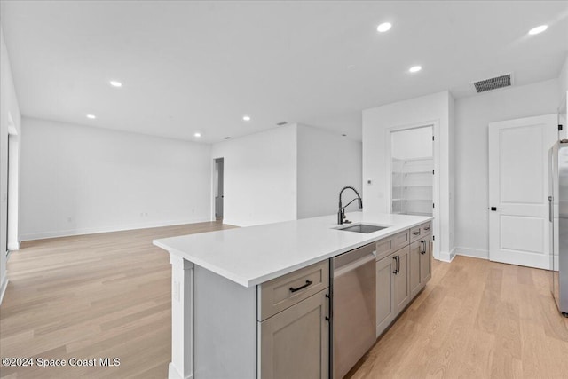 kitchen with stainless steel appliances, a sink, light wood-style flooring, recessed lighting, and light countertops
