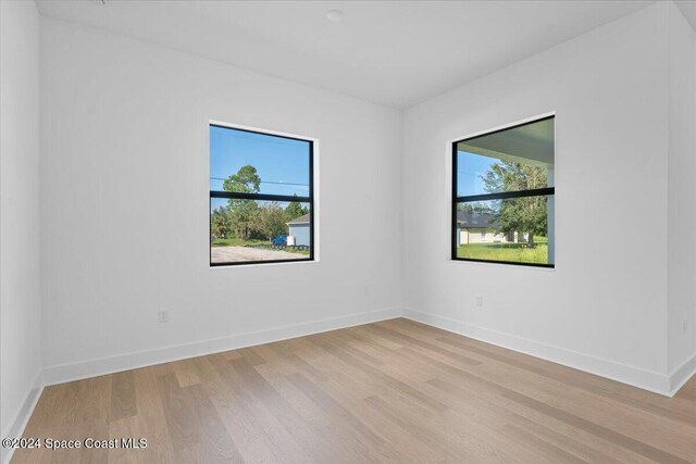 unfurnished room with light wood finished floors and baseboards