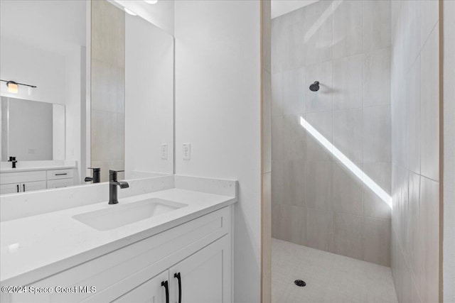 bathroom with vanity and a tile shower