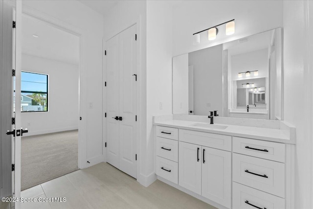 bathroom with vanity, baseboards, and tile patterned flooring