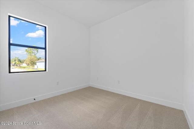 carpeted spare room featuring baseboards