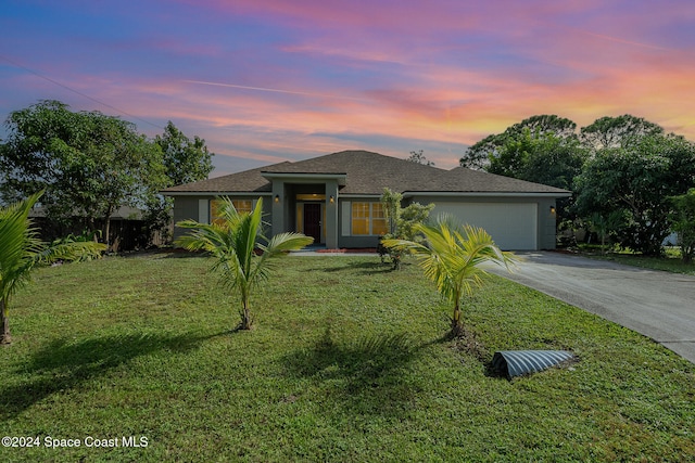 view of front of home with a garage and a yard