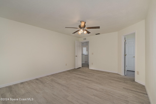 empty room with light wood-type flooring, a textured ceiling, and ceiling fan