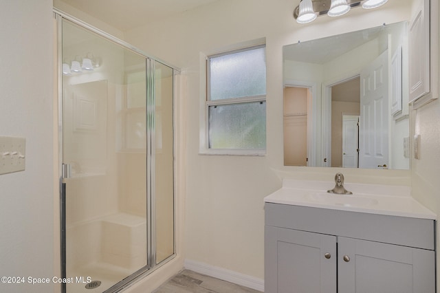 bathroom featuring walk in shower, wood-type flooring, and vanity