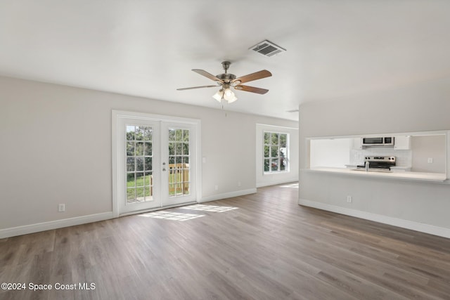 unfurnished living room featuring ceiling fan, wood-type flooring, and french doors