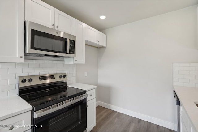 kitchen featuring decorative backsplash, white cabinetry, dark wood-type flooring, and appliances with stainless steel finishes