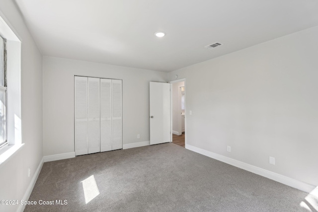 unfurnished bedroom featuring carpet and a closet