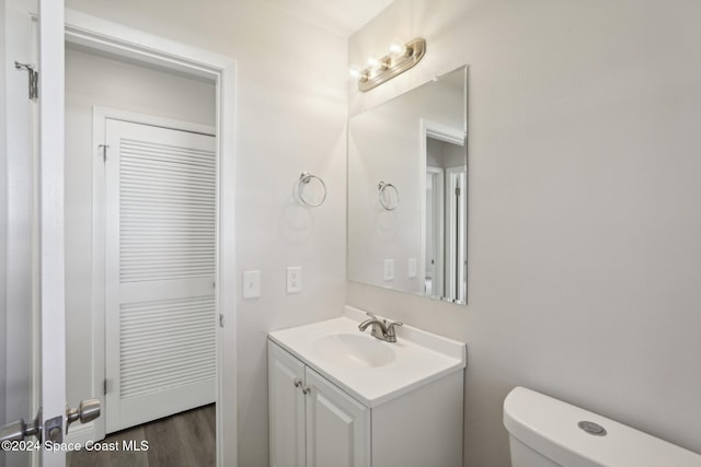 bathroom featuring hardwood / wood-style flooring, vanity, and toilet