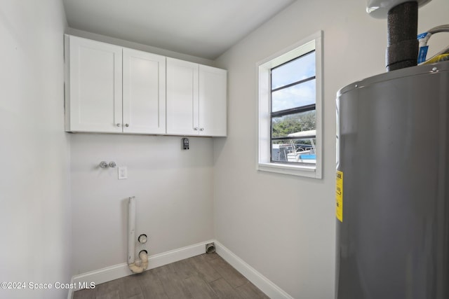 laundry room featuring cabinets, hookup for a washing machine, gas dryer hookup, dark wood-type flooring, and water heater