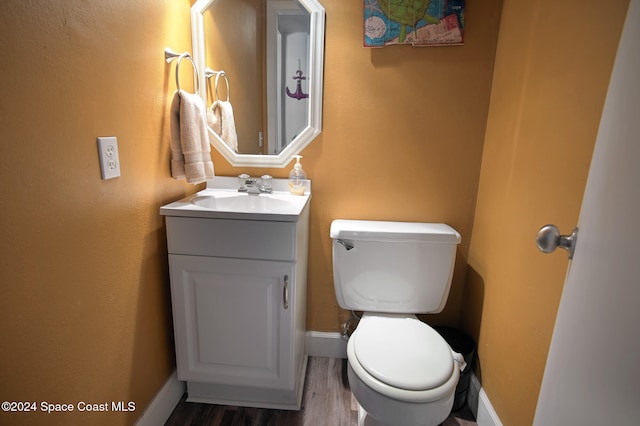 bathroom with hardwood / wood-style floors, vanity, and toilet