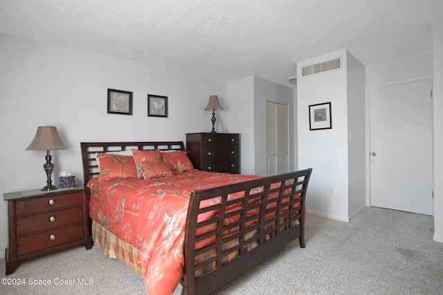 bedroom with light carpet, a textured ceiling, and a closet