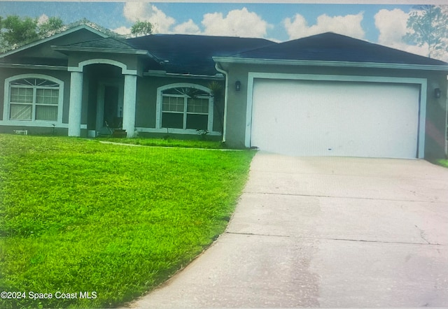 view of front of home featuring a garage and a front yard