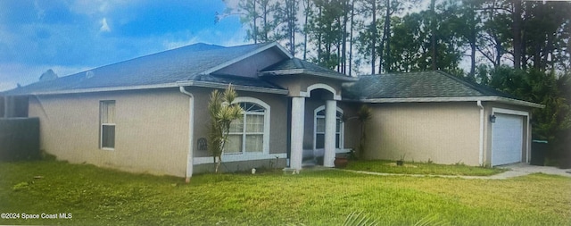 view of side of property featuring a garage and a yard