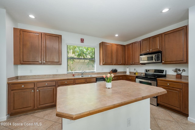 kitchen featuring stainless steel appliances, light tile patterned floors, sink, and a kitchen island