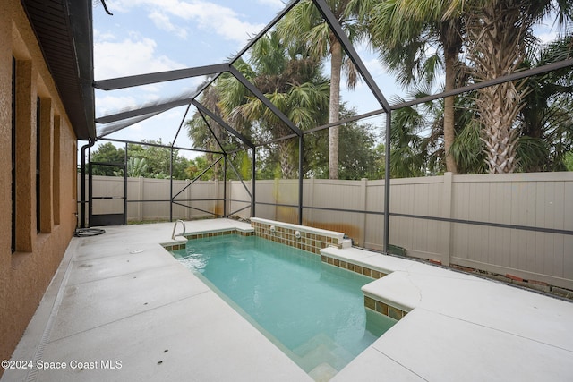 view of pool featuring glass enclosure and a patio