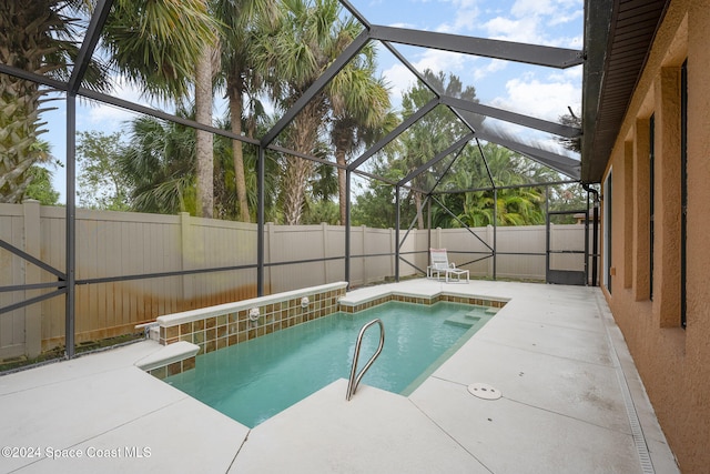 view of swimming pool with glass enclosure and a patio