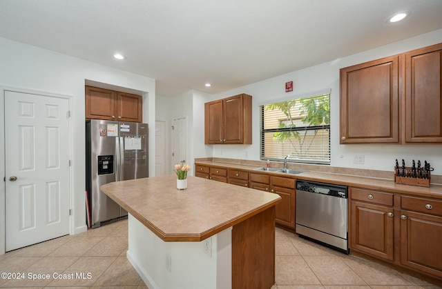 kitchen featuring light tile patterned floors, sink, a kitchen island, and appliances with stainless steel finishes