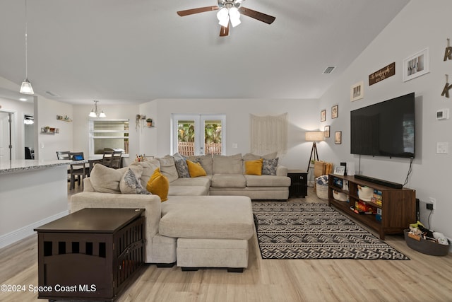 living room featuring ceiling fan, light hardwood / wood-style floors, and vaulted ceiling