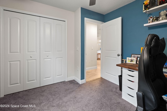 carpeted home office featuring ceiling fan