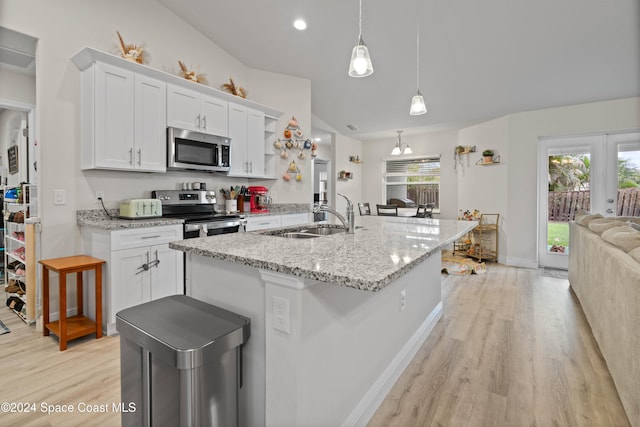 kitchen with white cabinets, decorative light fixtures, sink, and stainless steel appliances