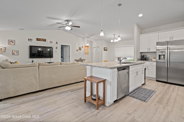 kitchen with sink, an island with sink, appliances with stainless steel finishes, decorative light fixtures, and white cabinetry