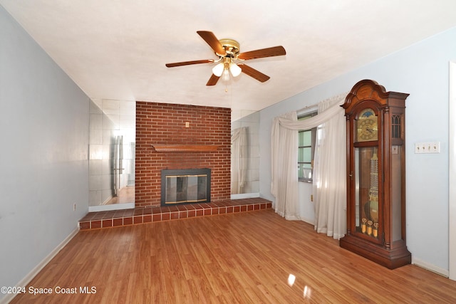 unfurnished living room with hardwood / wood-style flooring, ceiling fan, and a fireplace