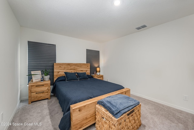 bedroom with a textured ceiling and carpet