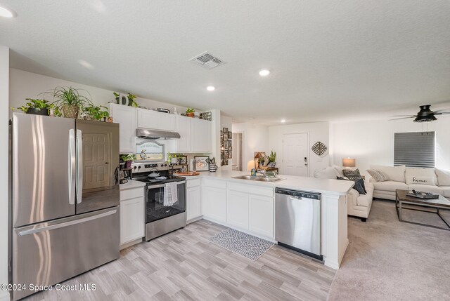 kitchen featuring light wood-type flooring, white cabinetry, kitchen peninsula, and stainless steel appliances