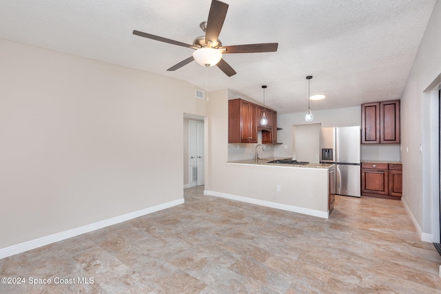 kitchen featuring pendant lighting, sink, a textured ceiling, kitchen peninsula, and stainless steel appliances