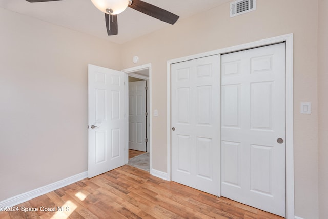 unfurnished bedroom featuring light wood-type flooring, a closet, and ceiling fan