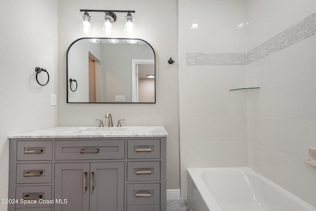 bathroom featuring vanity and tiled shower / bath