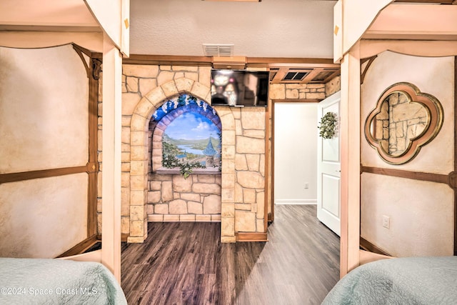 bedroom featuring wood-type flooring and a textured ceiling