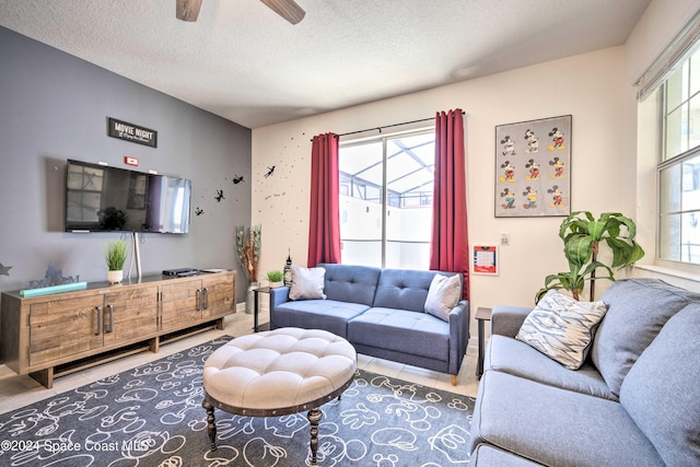 living room featuring ceiling fan and a textured ceiling