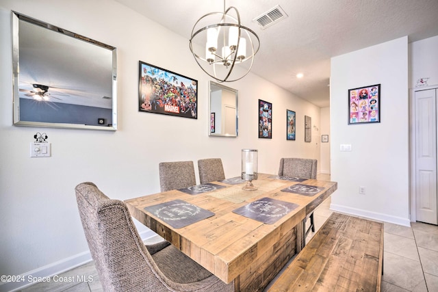 dining room with ceiling fan with notable chandelier, a textured ceiling, and light tile patterned floors