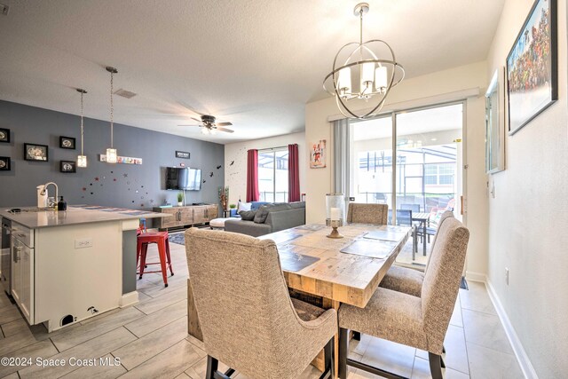 8988 Stinger Dr, Davenport, FL 33896 - dining area featuring a chandelier, ceiling fan, a textured ceiling, and baseboards