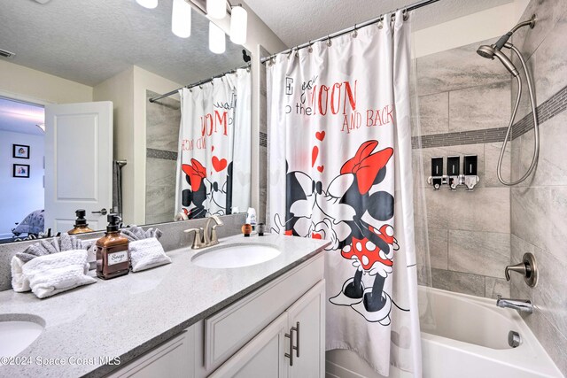 bathroom with vanity, a textured ceiling, and shower / tub combo