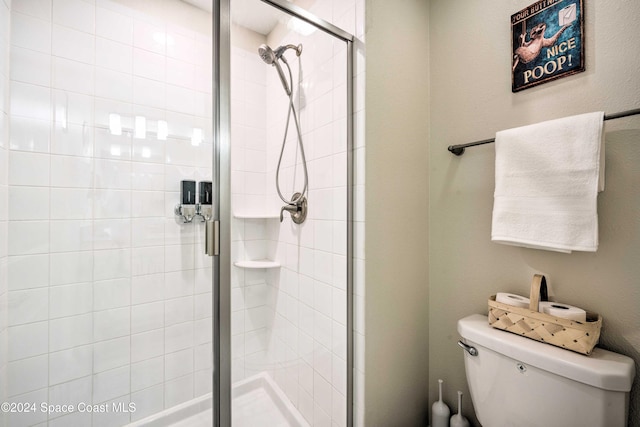 bathroom featuring toilet and an enclosed shower