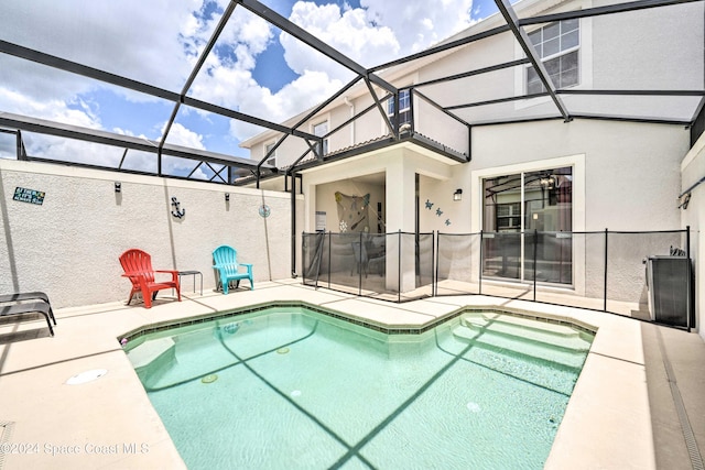 view of swimming pool featuring glass enclosure and a patio