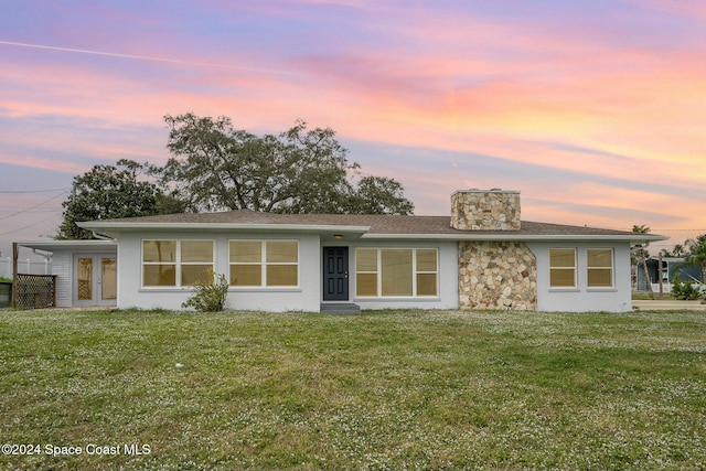3109 Indian River Dr, Cocoa, FL 32922 - view of front of property featuring a chimney, a yard, stucco siding, and stone siding