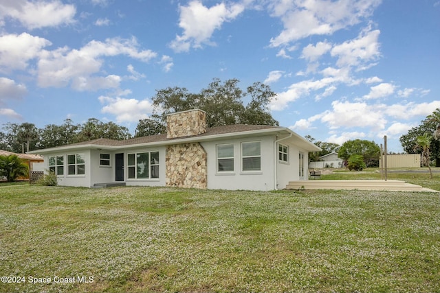 3109 Indian River Dr, Cocoa, FL 32922 - view of front of home featuring a front yard, stucco siding, and a chimney