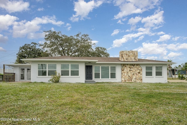 3109 Indian River Dr, Cocoa, FL 32922 - view of front of home featuring a front lawn, stucco siding, stone siding, and a chimney