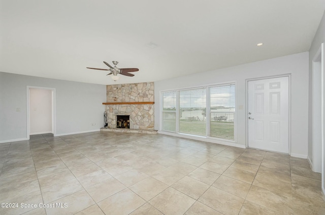 unfurnished living room featuring ceiling fan, a fireplace, and light tile patterned flooring