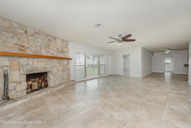3109 Indian River Dr, Cocoa, FL 32922 - unfurnished living room featuring a ceiling fan, baseboards, a stone fireplace, and tile patterned floors